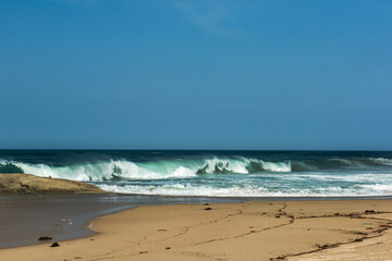 The big breaking waves during a strom at the beautiful summer sea shore background the blue sky and...