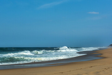 The big breaking waves during a strom at the beautiful summer sea shore background the blue sky and...