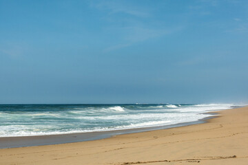 The big breaking waves during a strom at the beautiful summer sea shore background the blue sky and horizon