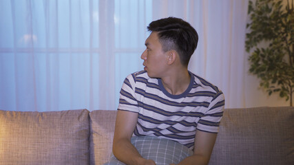 asian young man got spooky feelings seeing ghost movies alone at nighttime. oddly terrifying...