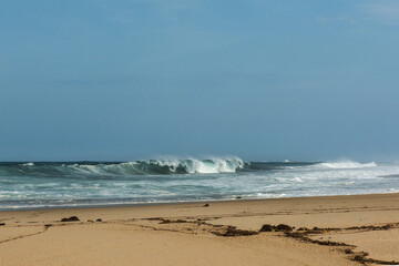 The big breaking waves during a strom at the beautiful summer sea shore background the blue sky and horizon
