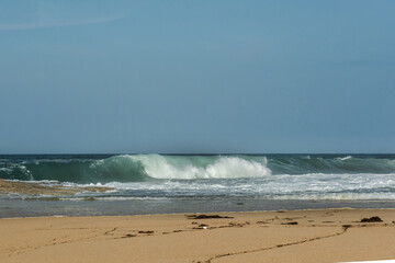 The big breaking waves during a strom at the beautiful summer sea shore background the blue sky and horizon