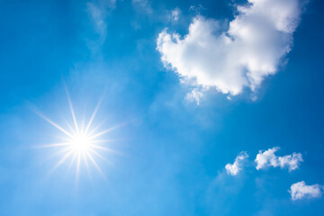 Naklejka na ściany i meble Hot summer or heat wave background, glowing sun on blue sky with clouds