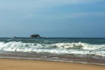 The big breaking waves during a strom at the beautiful summer sea shore background the blue sky and...