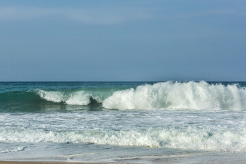 The big breaking waves during a strom at the beautiful summer sea shore background the blue sky and horizon