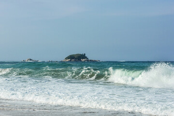 The big breaking waves during a strom at the beautiful summer sea shore background the blue sky and...