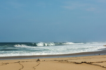The big breaking waves during a strom at the beautiful summer sea shore background the blue sky and...