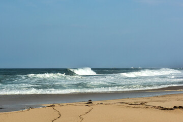 The big breaking waves during a strom at the beautiful summer sea shore background the blue sky and horizon