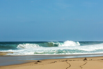 The big breaking waves during a strom at the beautiful summer sea shore background the blue sky and...