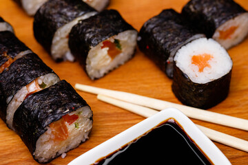 Sushi with salmon. Soy sauce, red caviar. Sushi on a black background.