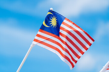 Malaysia flag against blue sky.