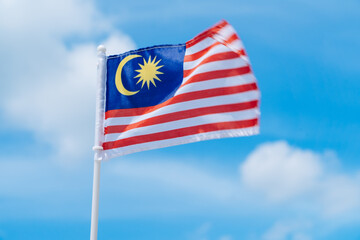 Malaysia flag against blue sky.