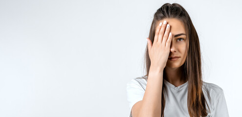 Photo of tired young woman with long chestnut hair, feels fatigue, needs good rest, isolated over...