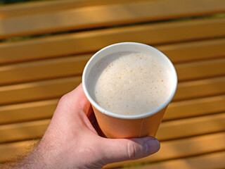 Male hand holding a paper cup of coffee, close-up