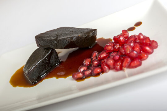 Closeup selective focus shot of  blodpudding with pomegranate on a plate