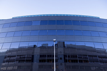 Modern building with blue glass windows under the sunlight at daytime