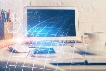 Double exposure of desktop with computer and world map hologram. International data network concept.