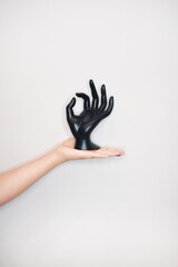 A woman's hand holds a plastic hand.