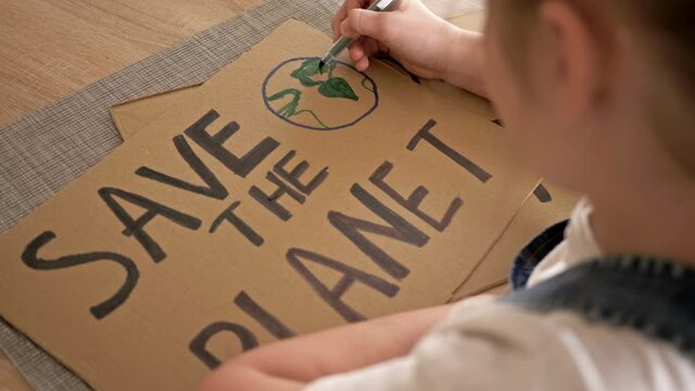 Schoolgirl makes a poster save the planet