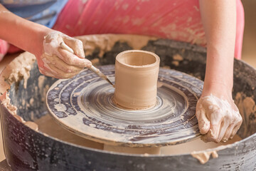 Fototapeta na wymiar Closeup shot of female ceramic artist works on pottery wheel in studio space, Creative People Handcrafted 
