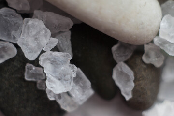 Macrophotography of a shell on round stones and large sea salt crystals