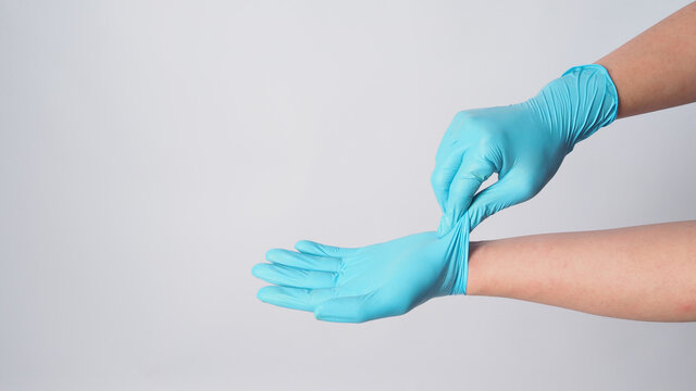 Hand Is Remove Blue Surgical Gloves By Grasp The Outside Of One Glove On White Background.