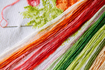 Colored threads for embroidery on a white embroidered canvas. - 369669423