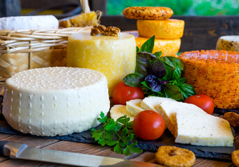 Cheese Heads with cheeses of different kinds. Assortment of different cheese types on wooden background. Fresh dairy product, various greens, nuts, honey, healthy organic food. Delicious apetizer
