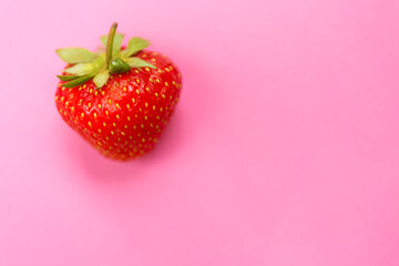 Fresh red strawberry on pink background. Close up photo.