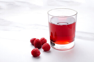 Closeup of glass of fresh raspberry drink on the white marble table.Empty space