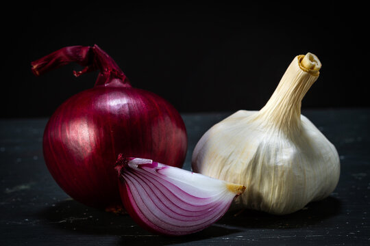 Red onion and head of garlic close-up on a black background. Food photography.