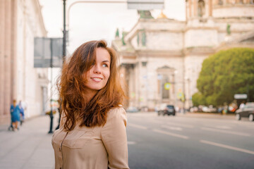 A happy Young woman walks through the historic streets of Saint Petersburg in the center of the city in summer