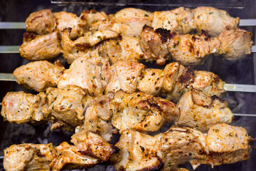 Juicy appetizing meat in pieces in spices on the grill, picnic and outdoor recreation, barbecue delivery