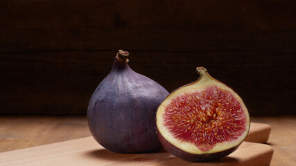 Fresh figs. A few figs on an old wooden background. Whole figs and one fig sliced. Autumn dish....