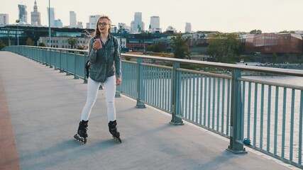 Young woman on rollerblades. Freedom concept. Roller skating on the urban bridge. High quality photo