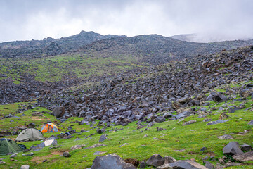ase camp at  Ararat Mountain, approximate elevation  of 3300 meters with green pasture and rocks ...
