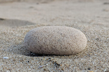 Fototapeta na wymiar A stone on the sand on the beach.