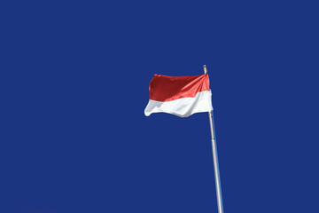Indonesian flag isolated on blue background.