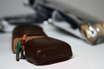 Scale worker cutting an energy bar of chocolate.