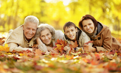 Fototapeta premium Portrait of happy family relaxing in autumn forest