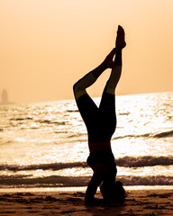 young woman doing yoga on the beach