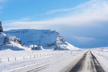 Highway road with snow and blue clear sky in Iceland.