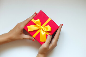 female hands with beautiful manicure hold a gift box