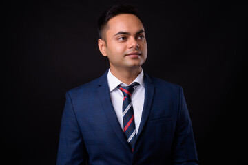 Portrait of young handsome Indian businessman in suit