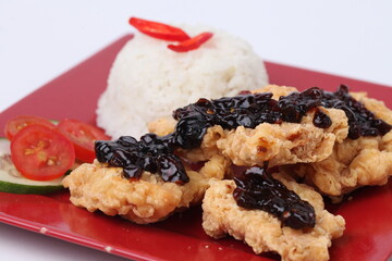 Fried chicken and rice on a red plate with black spicy flavor isolated on white background
