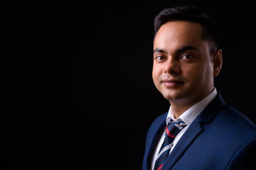 Portrait of young handsome Indian businessman in suit