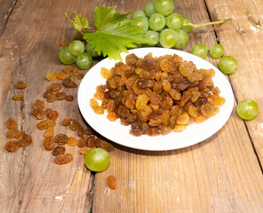 Natural organic dried grapes on a white dish, raisins, close up