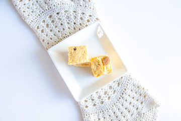 Soan papdi or patisa is a popular Indian dessert, it is cut in cube-shaped or served as flakes, and has a crisp and flaky texture.