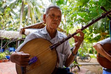 Old man from vietnam is playing music