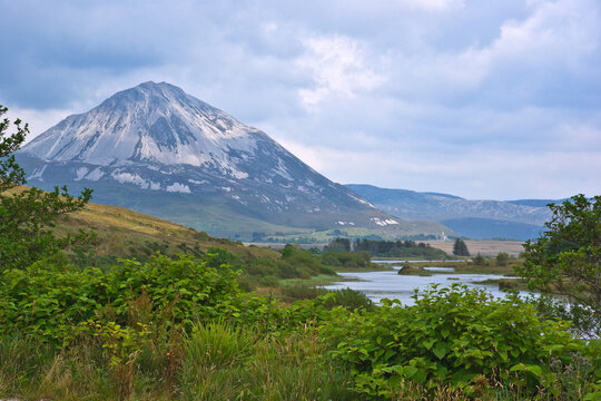The white quartzite peak of Errigal, the highest mountain in Donegal, Ireland, towers over the bog and moor land of the Dunlewey valley.